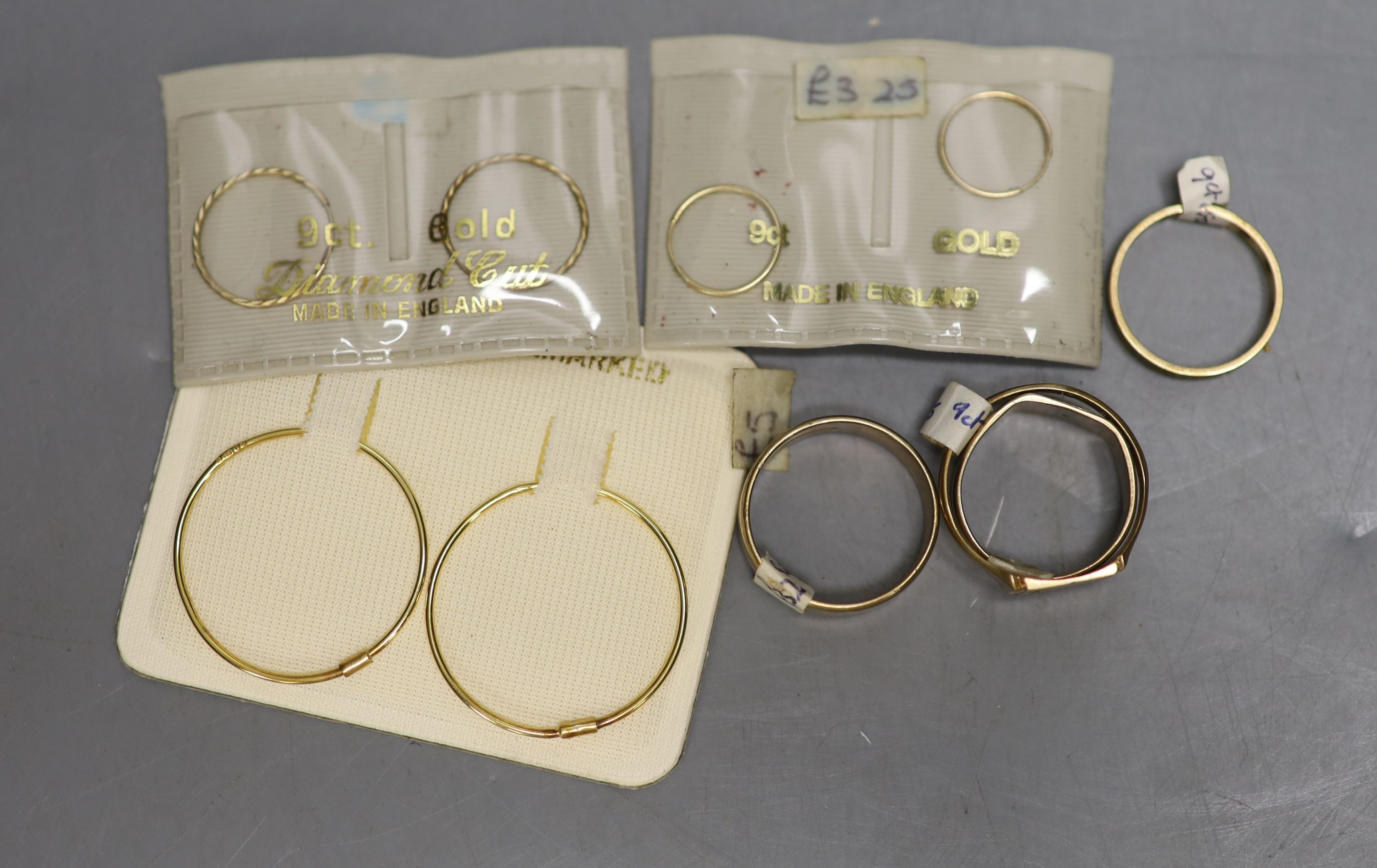 Four assorted 9ct rings, 13.5 grams and three pairs of 9ct hoop earrings in original packaging.